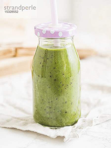 Grüner veganer Smoothie in einer Flasche