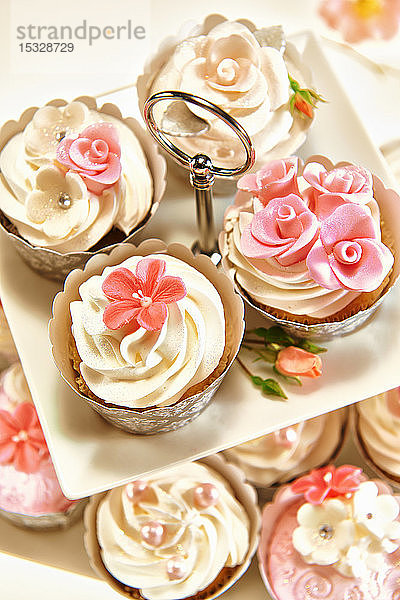 Festliche Cupcakes mit Sahnehäubchen und Zuckerblumen