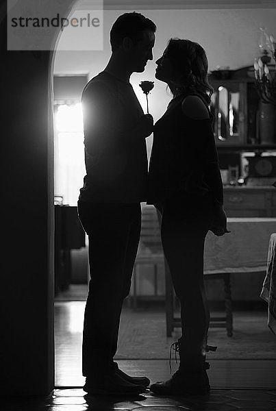 Silhouetten eines Paares mit Rose in der Tür