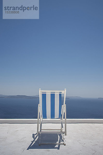 Gestreifter Liegestuhl auf Balkon am Meer in Santorini  Griechenland