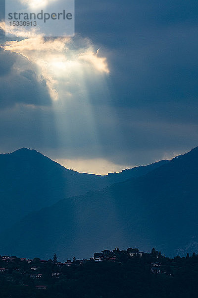 Sonnenstrahlen durch Wolken über Bergen in der Lombardei  Italien