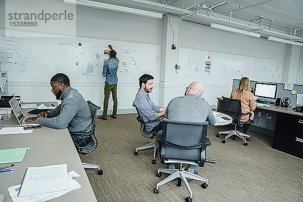 Arbeiter im Büro mit Whiteboard