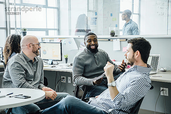 Lächelnde Männer bei einem Treffen im Büro