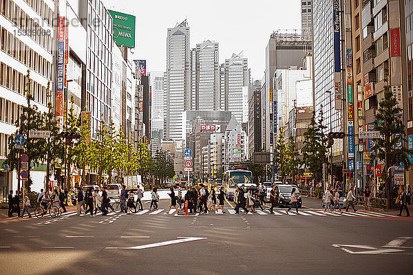 Menschen  die auf einem Fußgängerüberweg in Tokio gehen