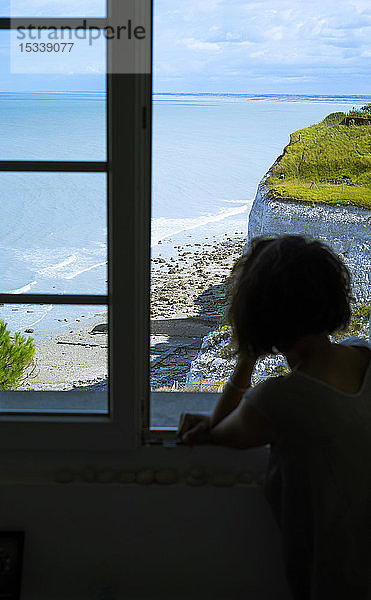 Frau schaut durch das Fenster