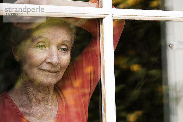 Frau schaut durch das Fenster