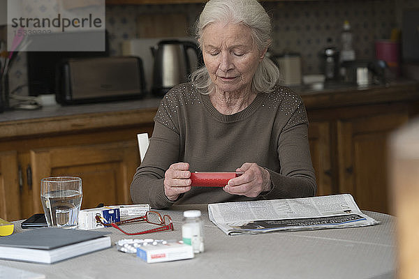 Frau schaut auf Pillendose