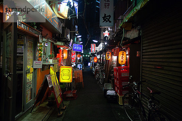 Beleuchtete Schilder von Geschäften und Bars bei Nacht
