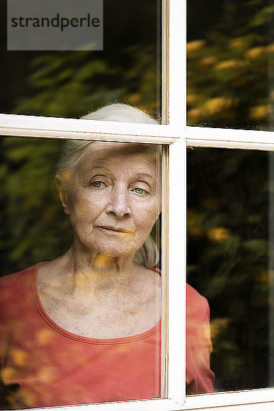 Frau schaut durch das Fenster