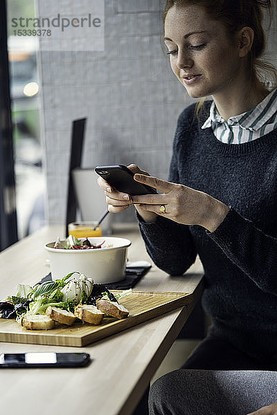 Junge Frau fotografiert im Restaurant