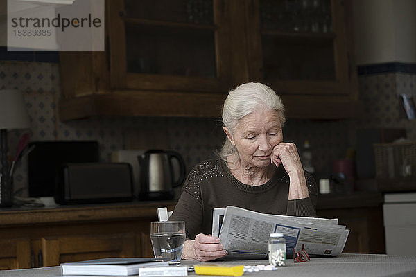 Ältere Frau liest Zeitung