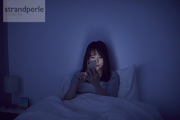 Junge japanische Frau im Bett
