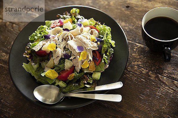 Salat und Kaffee auf dem Holztisch