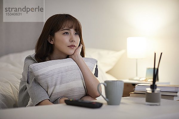 Junge japanische Frau im Schlafzimmer