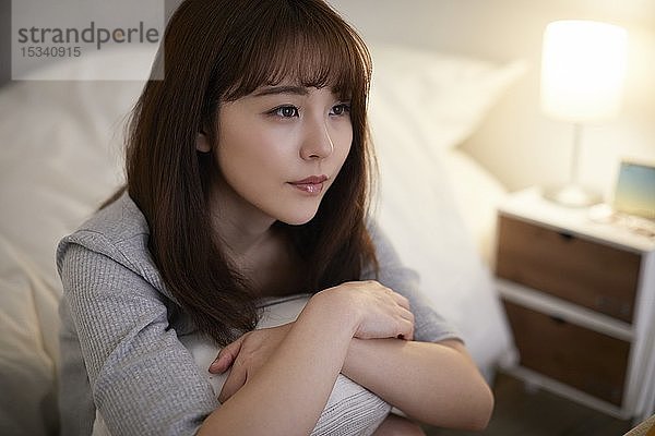 Junge japanische Frau im Schlafzimmer