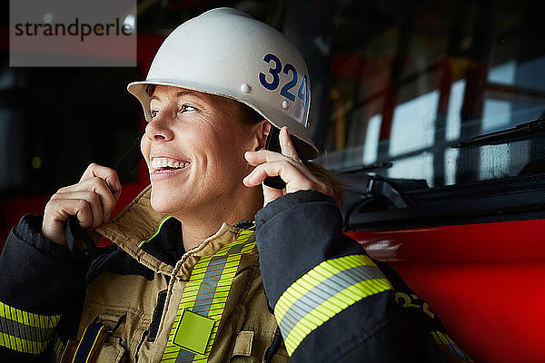 Lächelnde Feuerwehrfrau mit Helm auf der Feuerwache