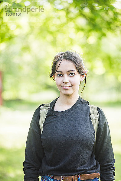 Porträt einer lächelnden jungen Frau  die im Freien steht