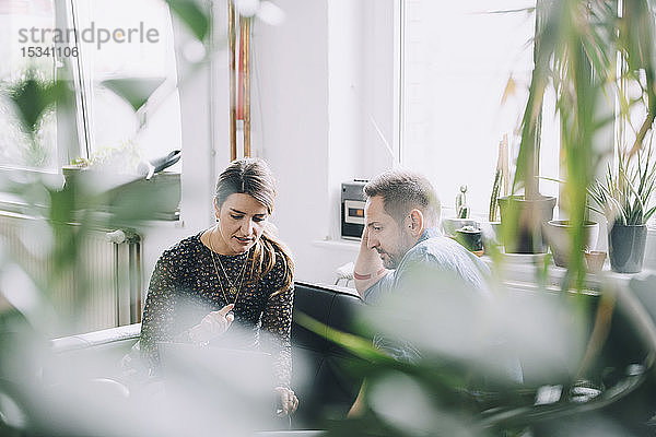 Geschäftsmann und Geschäftsfrau diskutieren im kreativen Büro