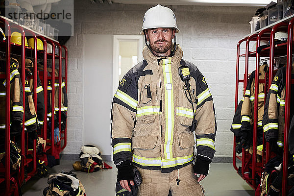 Porträt eines selbstbewussten männlichen Feuerwehrmannes in Schutzuniform in der Umkleidekabine der Feuerwache