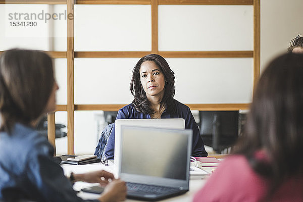 Weibliche Kollegen planen Strategie  während sie im Sitzungssaal sitzen