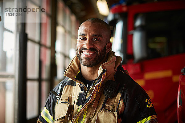 Porträt eines lächelnden männlichen Feuerwehrmannes in Uniform auf der Feuerwache