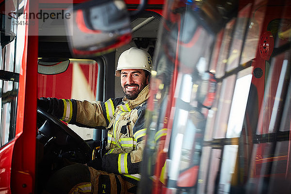 Porträt eines mittleren erwachsenen Feuerwehrmannes im Feuerwehrauto auf der Feuerwache