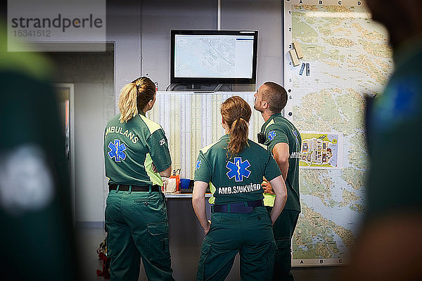 Sanitäter diskutieren  während sie im Krankenhaus auf den Bildschirm schauen