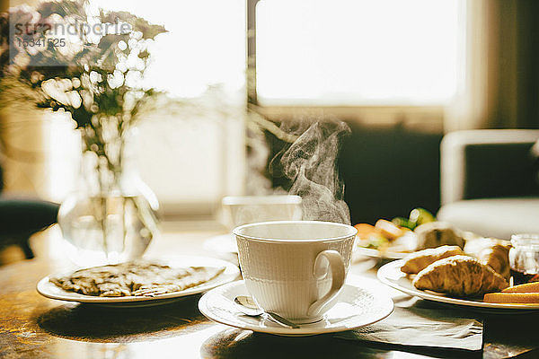 Heißer Kaffee mit Mahlzeit zum Frühstück auf dem Tisch im Hotelzimmer