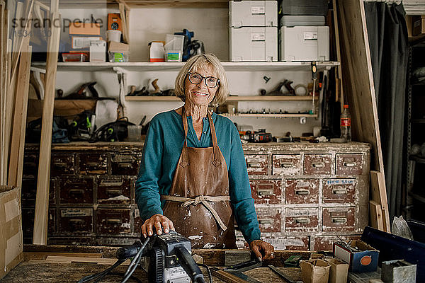 Porträt einer lächelnden Senior-Unternehmerin  die beim Workshop steht