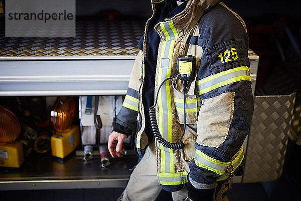 Mittelteil eines Feuerwehrmannes mit Walkie-Talkie in der Feuerwache