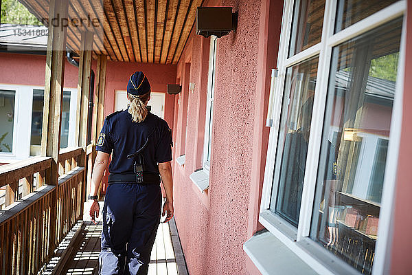 Rückansicht einer Polizistin auf dem Balkon einer Polizeistation