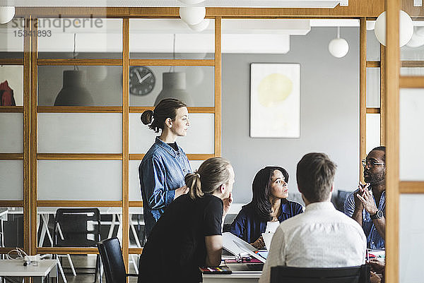 Männliche und weibliche Kollegen planen Geschäftsstrategien bei Treffen im Kreativbüro