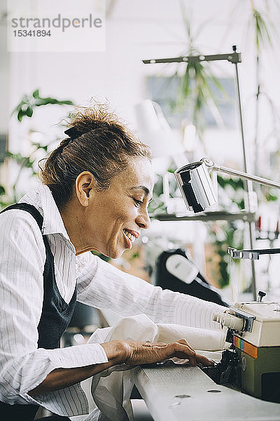 Lächelnde Geschäftsfrau  die im Kreativbüro arbeitet