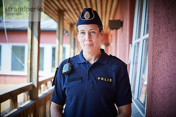 Porträt einer Polizistin  die auf dem Balkon einer Polizeistation steht