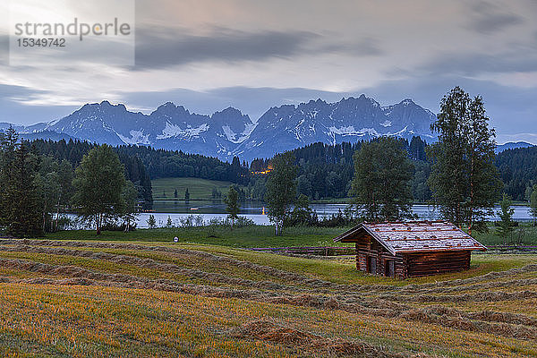 Blick auf eine traditionelle Blockhütte und die Kulisse des Kaisergebirges am Schwarzsee bei Kitzbühel  Tirol  Österreich  Europa