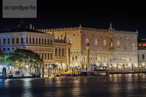 Nachtansicht der beleuchteten Fassade des Palazzo Ducale (Dogenpalast) mit Säulen am Markusplatz  gesehen von Dorsoduro  Venedig  UNESCO-Weltkulturerbe  Venetien  Italien  Europa