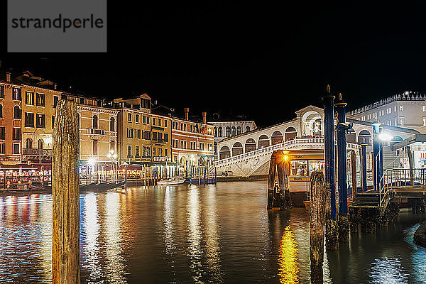 Nachtansicht der beleuchteten Ponte di Rialto  Rialto-Fußgänger-Steinbogenbrücke und traditionelle Gebäude am Canal Grande  Venedig  UNESCO-Weltkulturerbe  Venetien  Italien  Europa