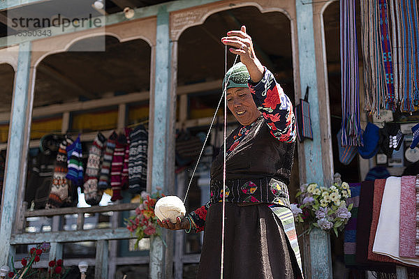 Eine Sherpa-Frau aus Gosainkund spinnt Baby-Yak-Wolle nach der traditionellen Methode mit einer Spindel  Langtang-Region  Nepal  Asien