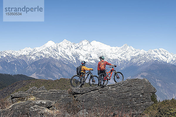 Mountainbiking im Himalaya mit Blick auf die Langtang-Bergkette in der Ferne  Nepal  Asien