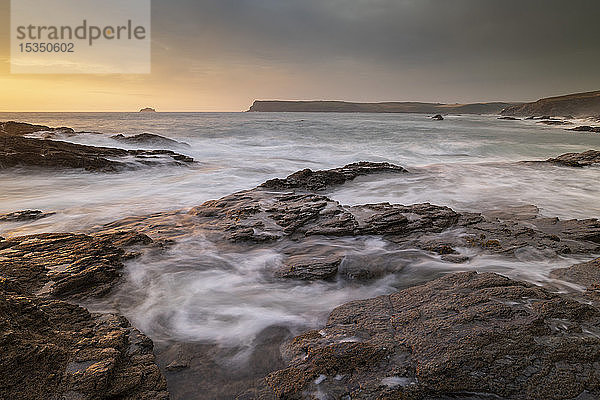 Wellen wirbeln über Felsvorsprünge bei Sonnenuntergang an der Küste von North Cornwall  Cornwall  England  Vereinigtes Königreich  Europa