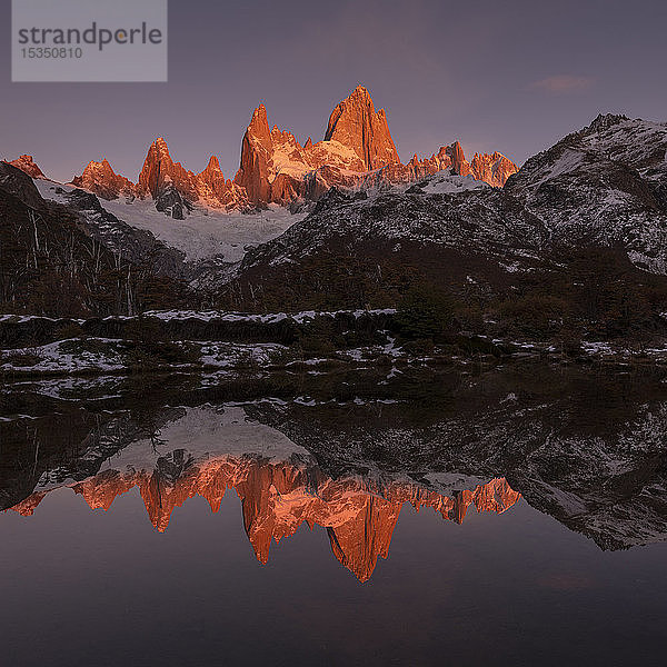 Die Bergkette mit dem Cerro Fitz Roy bei Sonnenaufgang spiegelt sich im See  Nationalpark Los Glaciares  UNESCO-Weltkulturerbe  El Chalten  Provinz Santa Cruz  Patagonien  Argentinien  Südamerika