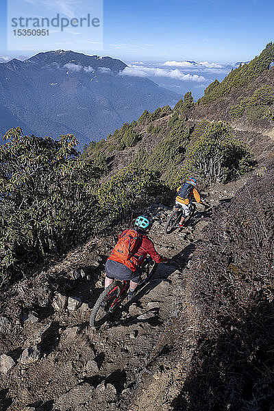 Mountainbikes rasen auf einem einspurigen Weg im Enduro-Stil im nepalesischen Himalaya in der Nähe der Langtang-Region vorbei  Nepal  Asien