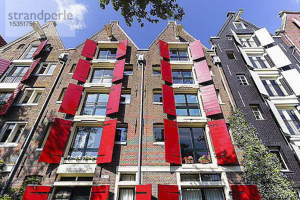 Rote Fensterläden an einem Gebäude im traditionellen holländischen Stil  Amsterdam  Nordholland  Niederlande  Europa