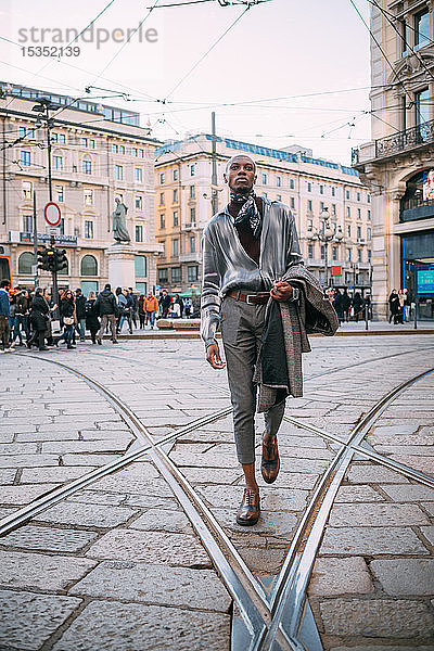 Stilvoller Mann geht über Straßenbahnschienen auf der Piazza  Mailand  Italien