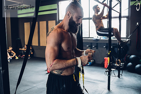 Junge Männer trainieren im Fitnessstudio  an der Übungsstange