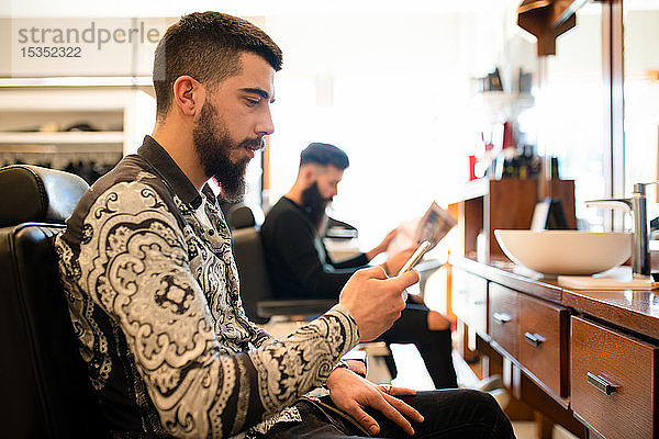 Wartende und lesende Kunden beim Friseur