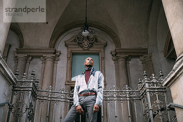 Stilvoller Mann steht auf Stufen eines historischen Gebäudes  Mailand  Italien