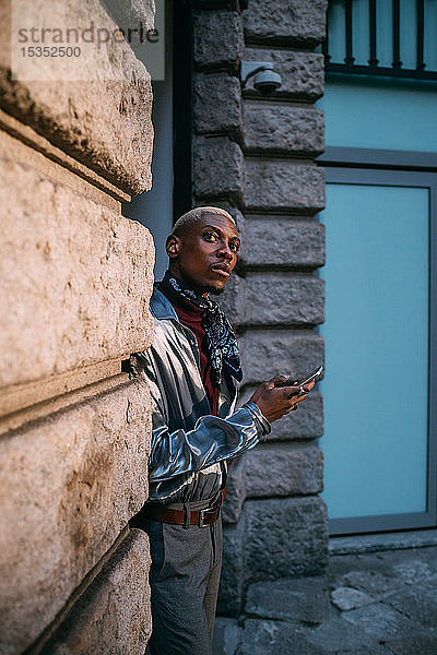 Stilvoller Mann benutzt Handy nach Gebäude der Epoche  Mailand  Italien
