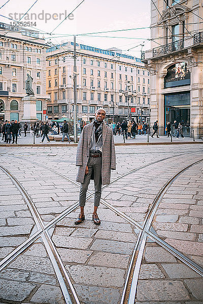 Stilvoller Mann posiert auf Straßenbahnschienen auf der Piazza  Mailand  Italien