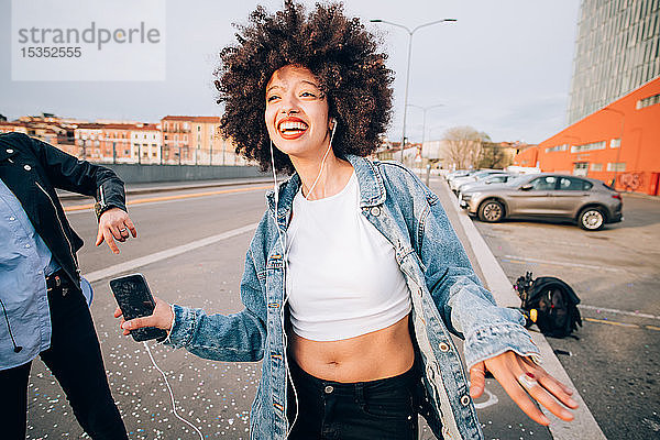 Freunde tanzen auf der Straße zu Smartphone-Musik  Mailand  Italien